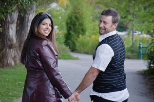 Candidate for Town of Aurora Councillor, Ward 4, Shaheen Moledina (left) smiles and holds hands with her husband (right) while walking along a paved path in a lush, green outdoor setting. This photograph highlights her deep personal roots in Aurora, reflecting her 15-year history as a resident and the community where she chose to start her married life in 2010.
